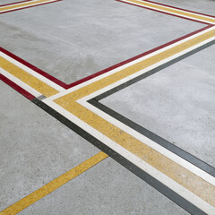 Fototapeta premium Geometric Concrete Floor with Red Yellow and Black Linear Inlays