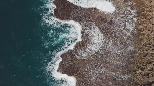 Aerial top down view of the Hawaiian shore with powerful waves breaking over the reef