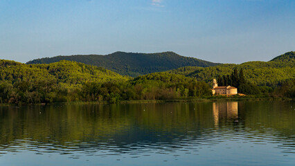 Fototapeta premium Historic Stone Church Reflected in Calm Lake at Sunset