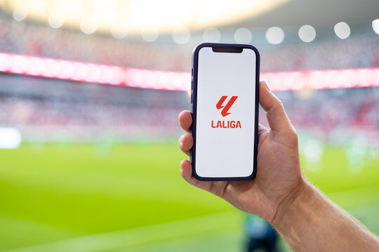 MINSK, BELARUS JUNE 9, 2026: Man holding Apple iPhone 12 in the stadium. The official logo of the Spanish championship in football, La Liga. Liga de Futbol Profesional, LFP