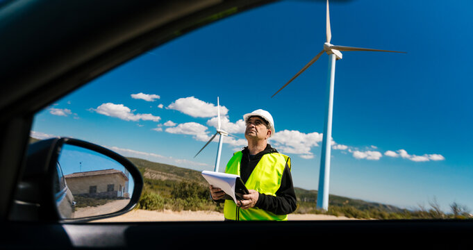 Engineer inspecting wind turbines on a wind farm