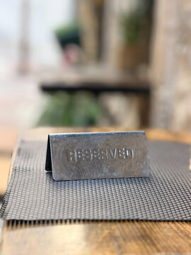 Close-up of a reserved table sign on a cafe table, restaurant reservation concept and hospitality service