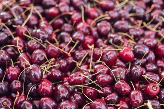 Fresh farm-grown sweet cherries displayed in a wooden crate at a local farmers market, seasonal summer fruit and natural food concept