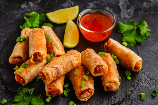 Fried spring rolls served with sauce and lime