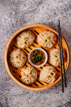 Steamed dumplings served in a bamboo basket with dipping sauce