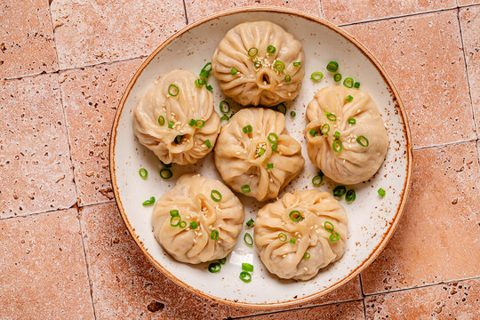 Dumplings served with green onions on a plate