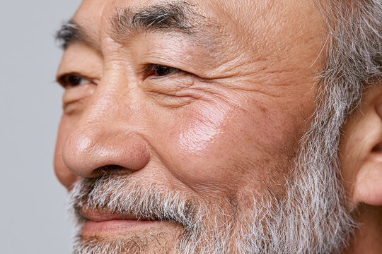 Elderly Japanese man portrait close up cheekbone wrinkle smile beard skin texture contemplative expression