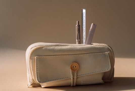 School pencil case with pens in dramatic warm sunlight, back to school still life.