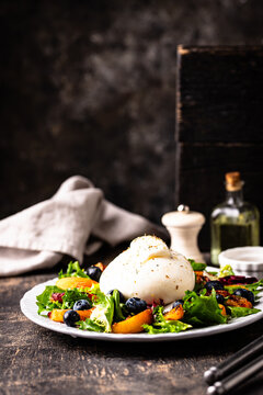 Delicious salad with burrata cheese grilled peaches and blueberry