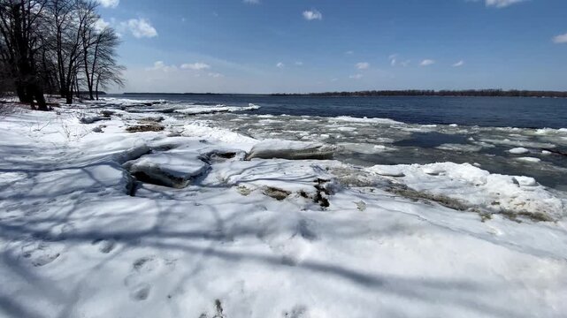 Water flowing from a concrete culvert storm drain pipe into a rocky creek bed during winter snowmelt in a forest.