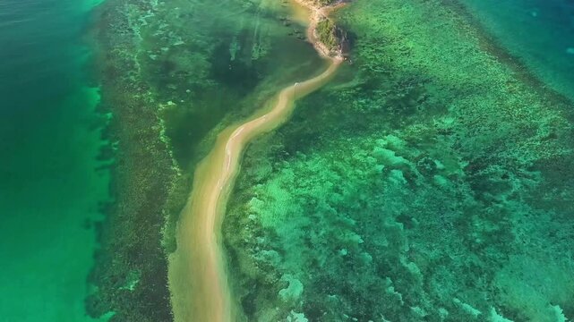 Aerial 4K drone footage of Lakdayan Sandbar in Busuanga, Palawan, Philippines, showing a curved white sandbar extending through crystal-clear turquoise waters beside a lush tropical island