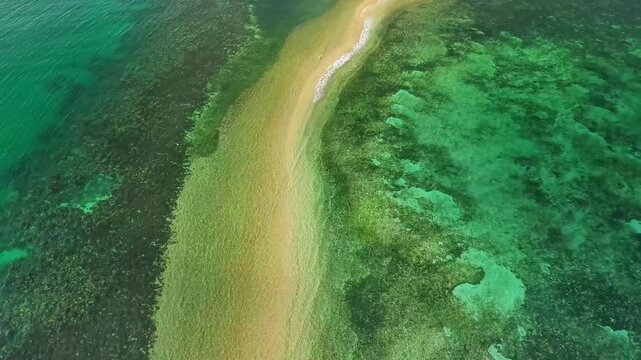 Aerial 4K drone footage of Lakdayan Sandbar in Busuanga, Palawan, Philippines, showing a curved white sandbar extending through crystal-clear turquoise waters beside a lush tropical island