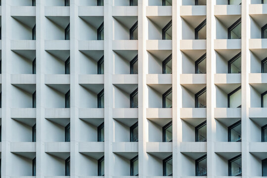Modern white building facade with repetitive geometric windows in Hong Kong city, China. Abstract architecture background, symmetry, rhythm, modular design, simplicity and urban construction