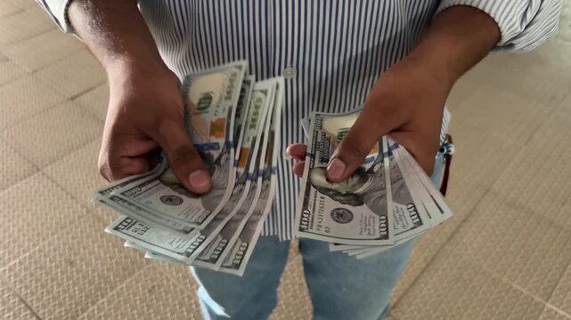 Close up shot of an hand counting cash outdoors, male hands holding and counting USD $ currency cash, finance and investment concept