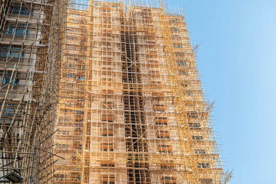 High rise building covered with bamboo scaffolding in Hong Kong city, China. Urban construction, renovation, skilled craftsmanship, traditional building techniques, sustainable building material