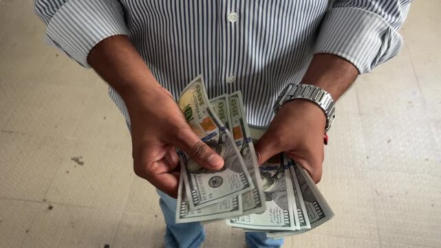 Close up shot of an hand counting cash outdoors, male hands holding and counting USD $ currency cash, finance and investment concept