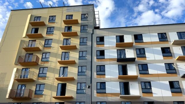 Painting the facade of residential building. New facade block building before painting. Building Construction, renovation. Construction work at height, facade cleaning, plastering. Insulation and wall