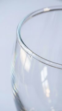 Single wine glass edge gleams against soft white background