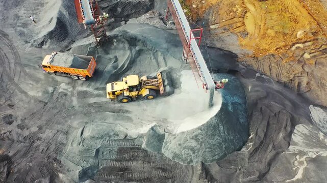 Aerial view of heavy machinery operating in a coal mine or industrial rock quarry