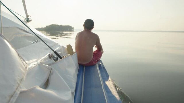 Person sits on the boat and enjoys the ride on the calm lake