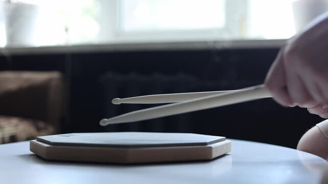 Close-up of hands practicing drum beats on a practice pad