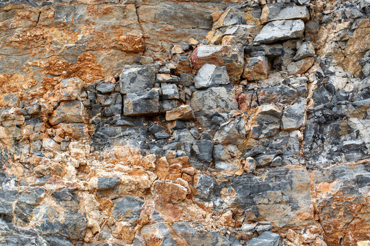 Detailed Texture of Fractured Grey Sedimentary Rock Face with Mineral Veins