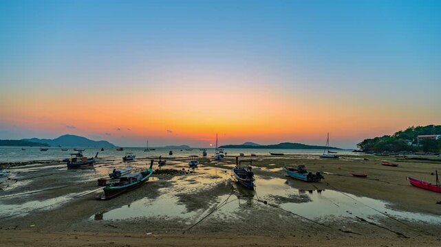 Time lapse Scenic tropical sunset with colorful clouds, island silhouette, and anchored boats on calm water. Ideal for travel, tourism, marine, and nature themed projects.