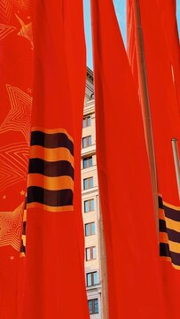 Red victory banners with Saint George ribbons against a city building background
