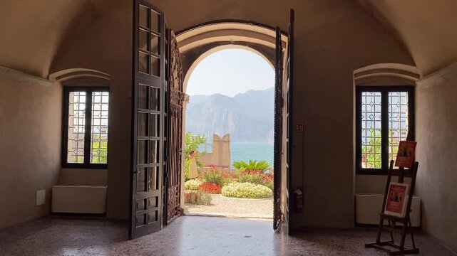 View through a historic palace archway over Lake Garda and the mountains in Malcesine, Italy