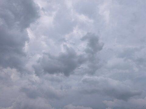 Dark dramatic storm clouds covering the sky before rain, abstract textured grey background for design.
