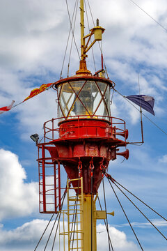 Historic Ship Lighthouse and Navigation Lantern against Blue Sky