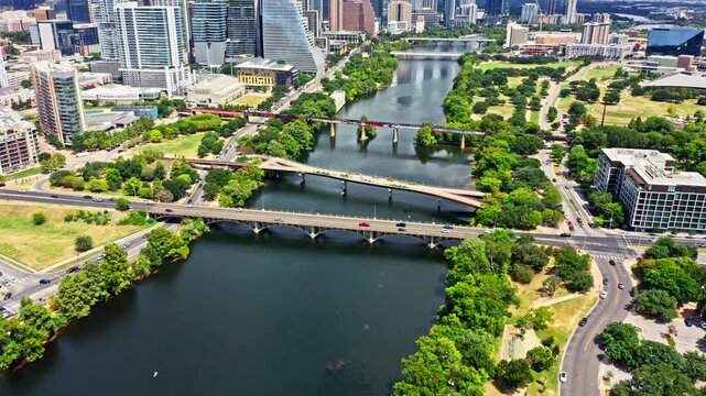 Aerial establishing shot of Austin, Texas skyline with slow camera uptilt, along Colorado river. Austin is the capital city of the U.S. state of Texas.