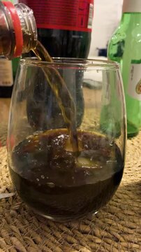 Effervescent cola and Fernet alcoholic drink bubbling in a glass with ice for traditional Argentine party