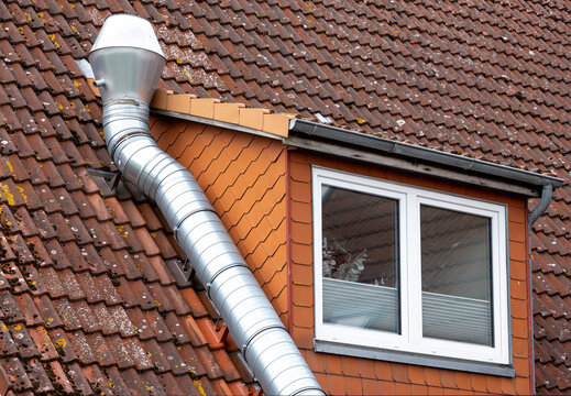 Metal Ventilation Duct on Tiled Roof with Dormer Window