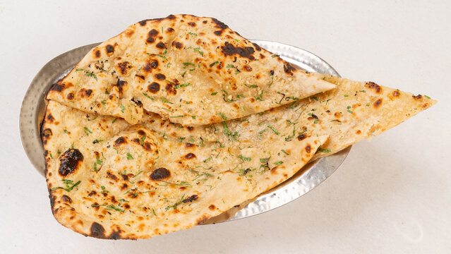 Traditional Indian garlic naan bread with melted butter and fresh cilantro.