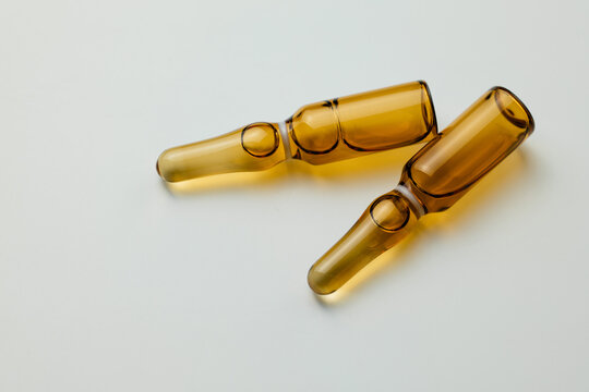 Two amber glass ampoules placed on a clean surface