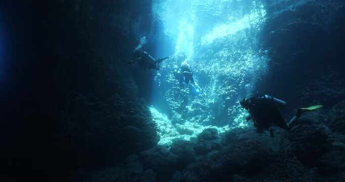 cave diving underwater scuba divers exploring caves and having fun ocean scenery sun beams and rays background