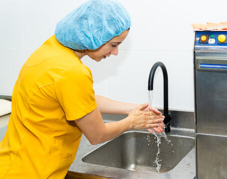 Woman washing hands in honey packaging plant