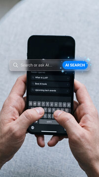Hand holding smartphone with AI search bar and keyboard, symbolizing digital interaction, technology, and information gathering