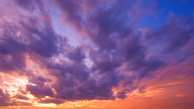 Dramatic sunset sky with vibrant purple, violet, pink, and orange overcast clouds. Colorful dusk atmospheric background for nature design.