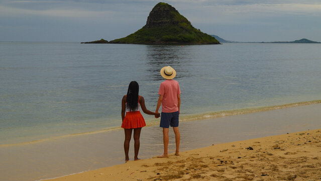 Interracial couple standing on a beach in Hawaii