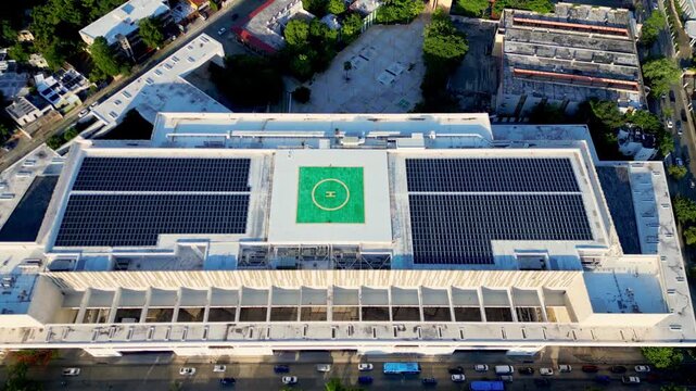 Aerial view of a solar panel farm and a helipad on a hospital rooftop