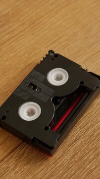 Mini DV cassette dropped onto wooden surface
