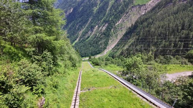 Kaprun Mountain Funicular Descending Through Alpine Landscape

Open funicular railway descending steep mountainside in Kaprun, Austria, 11 August 2026.
