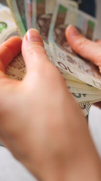 A closeup view of cash being stored in a blue wallet for financial purposes.