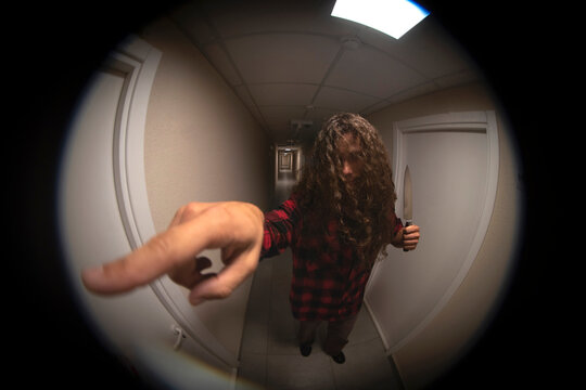 Color door peephole view of creepy stranger ringing doorbell with copy space