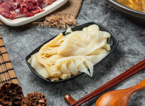Fresh raw beef tripe on a black plate for hot pot cooking