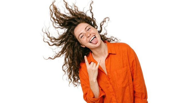 Joyful curly haired woman in bright orange shirt, laughing portrait on white background, energetic studio fashion photo