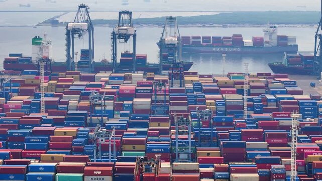 Indonesia - 18 July 2026: Aerial view of Port of Tanjung Priok with rows of colorful shipping containers and large cargo ships docked at the harbor.