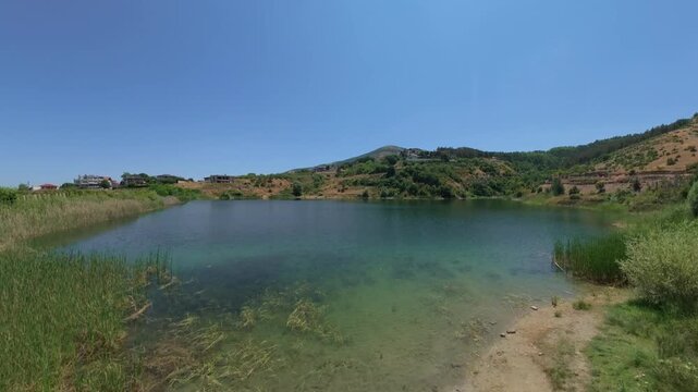 Drone view over a pond close above the water